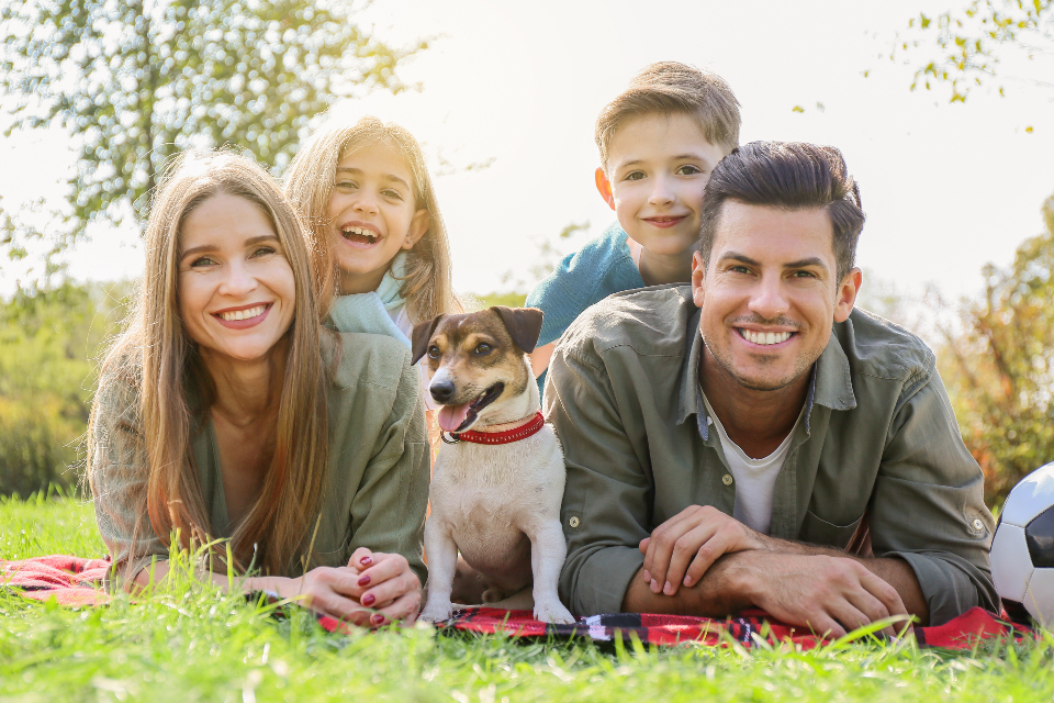Famille allongée dans l'herbe avec son chien